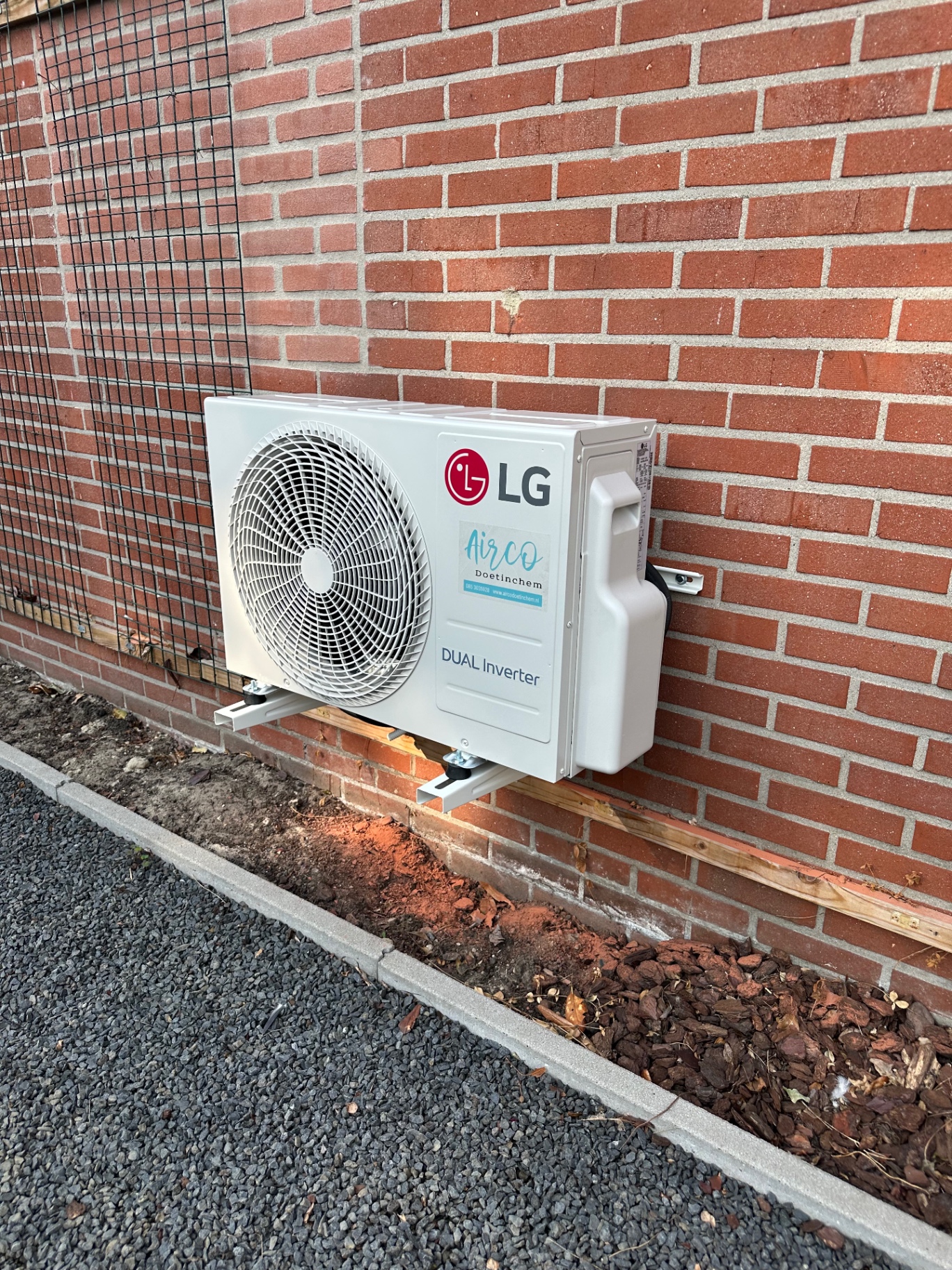 LG DUAL Inverter buitenunit laag geplaatst tegen een bakstenen gevel in Doetinchem
