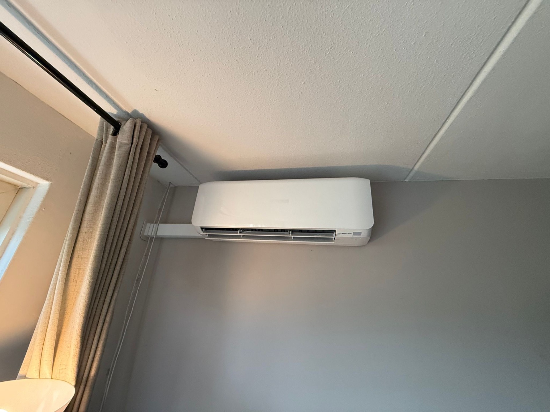 Mitsubishi Heavy binnenunit strak gemonteerd bovenaan een grijze wand