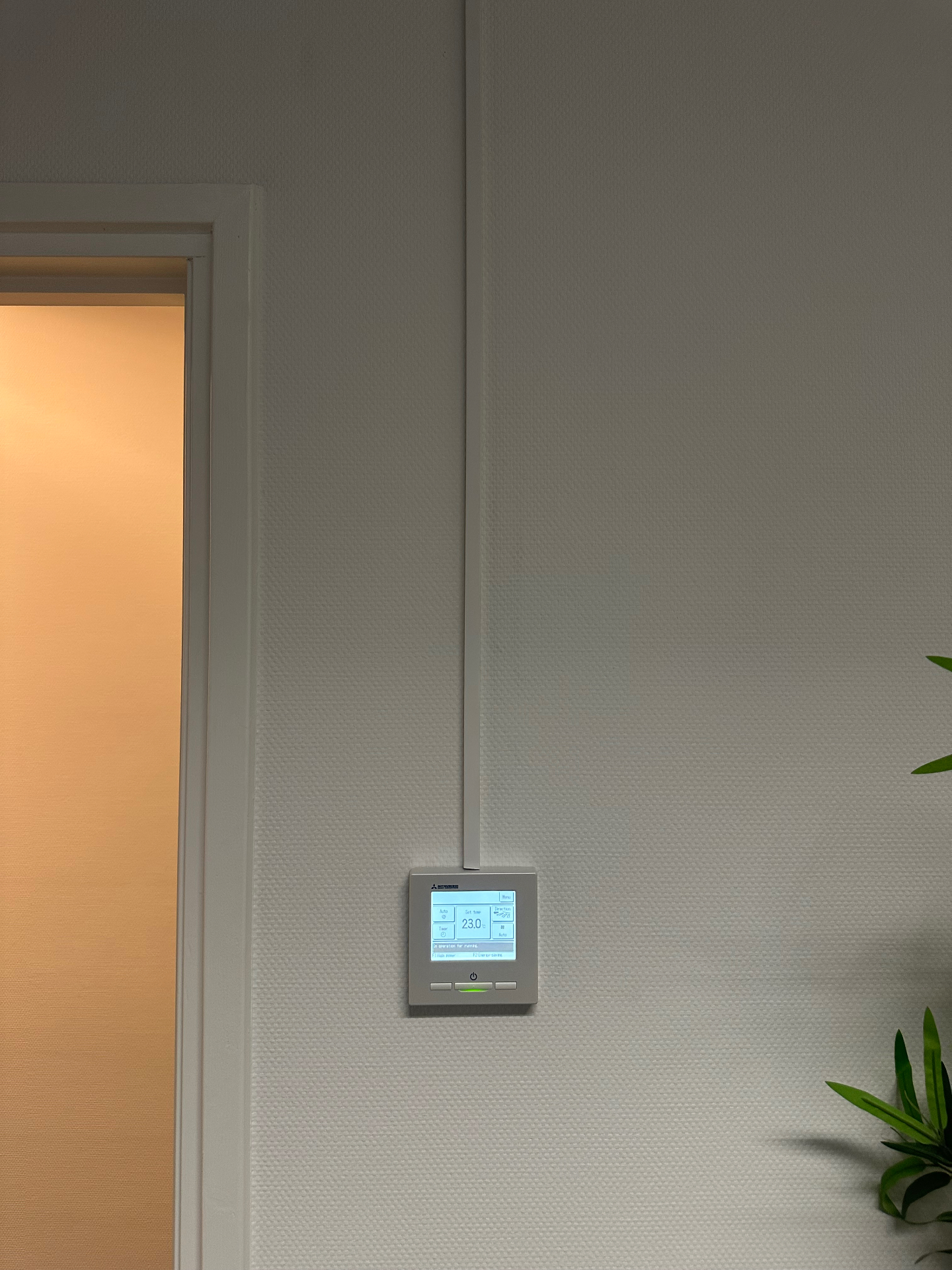 Bedrade Mitsubishi wandbediening met ingestelde temperatuur van 23 graden