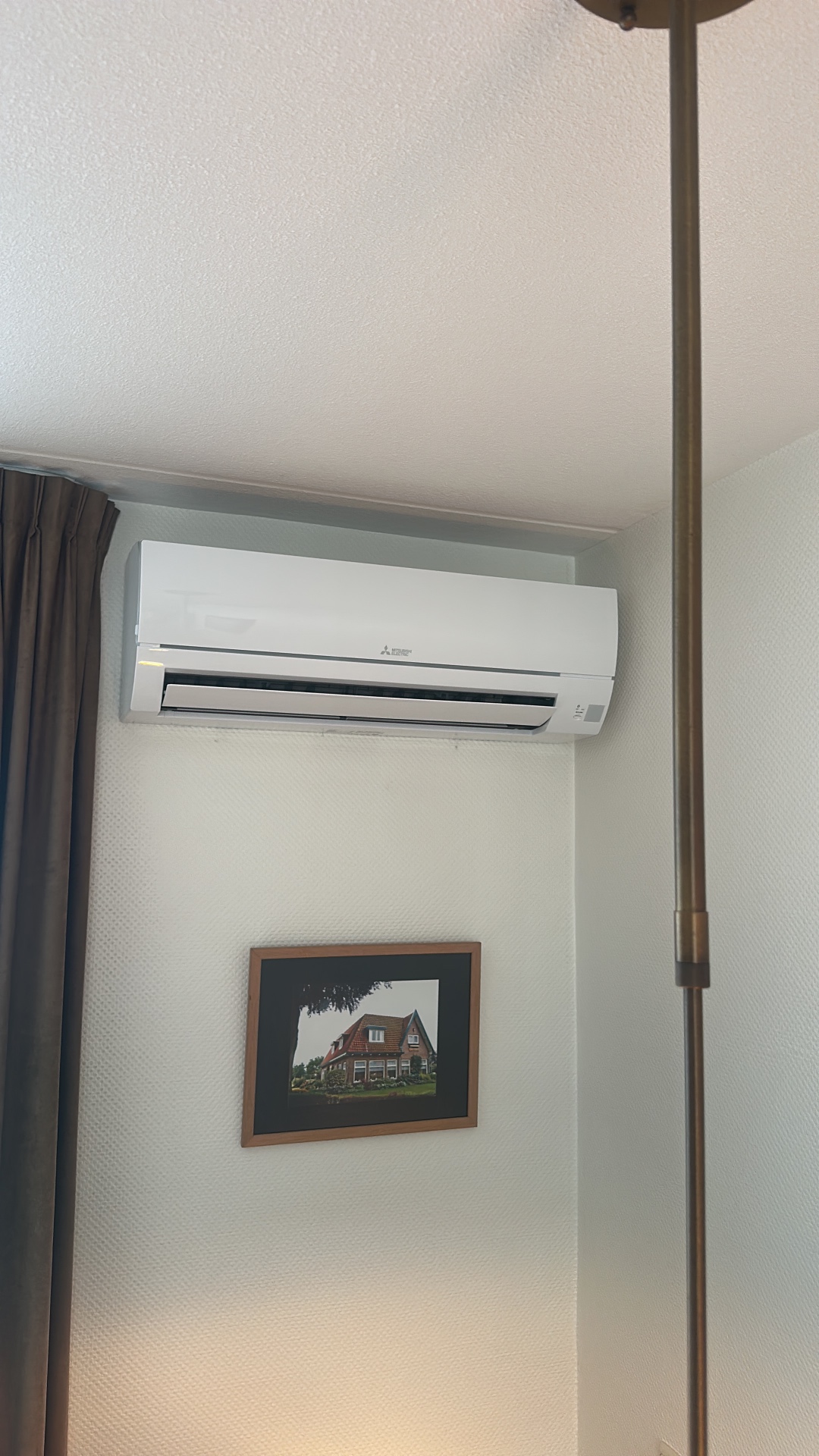 Mitsubishi Electric binnenunit strak gemonteerd hoog aan een lichte wand