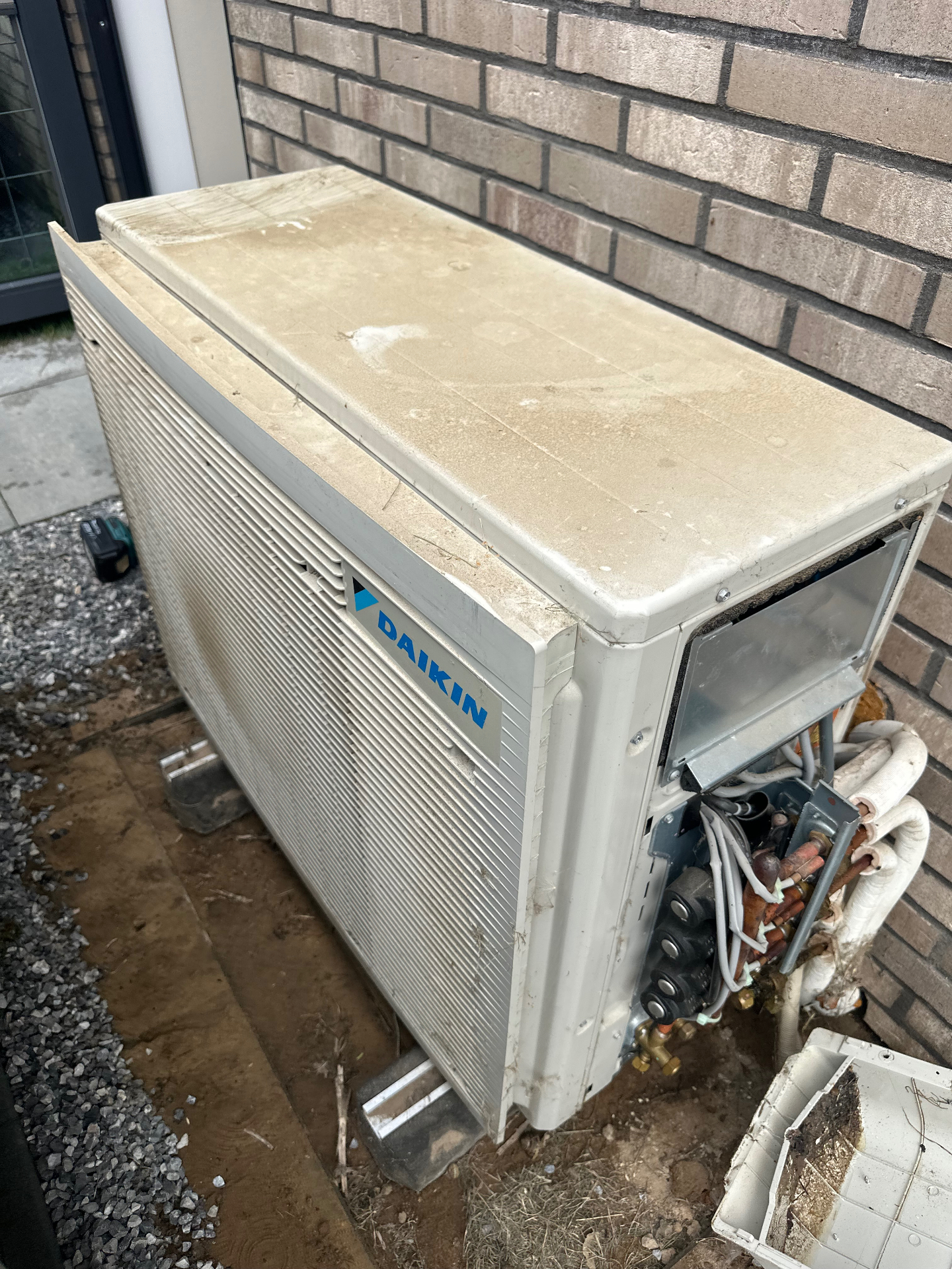 Vervuilde Daikin buitenunit vóór een onderhoudsbeurt