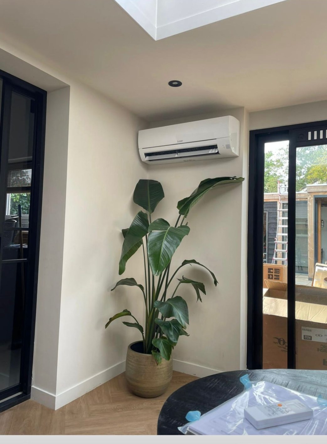 Mitsubishi wandunit in een lichte tuinkamer met plant