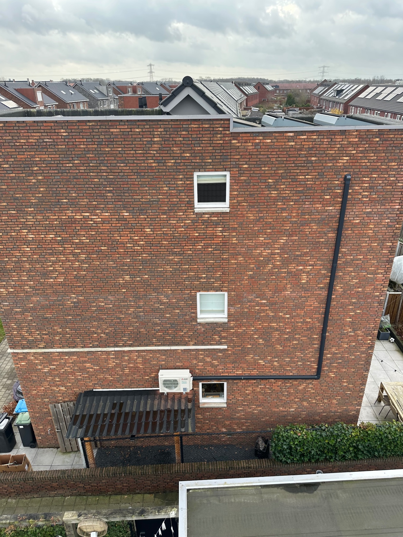 Bovenaanzicht van de woning met de Mitsubishi Electric buitenunit aan de gevel