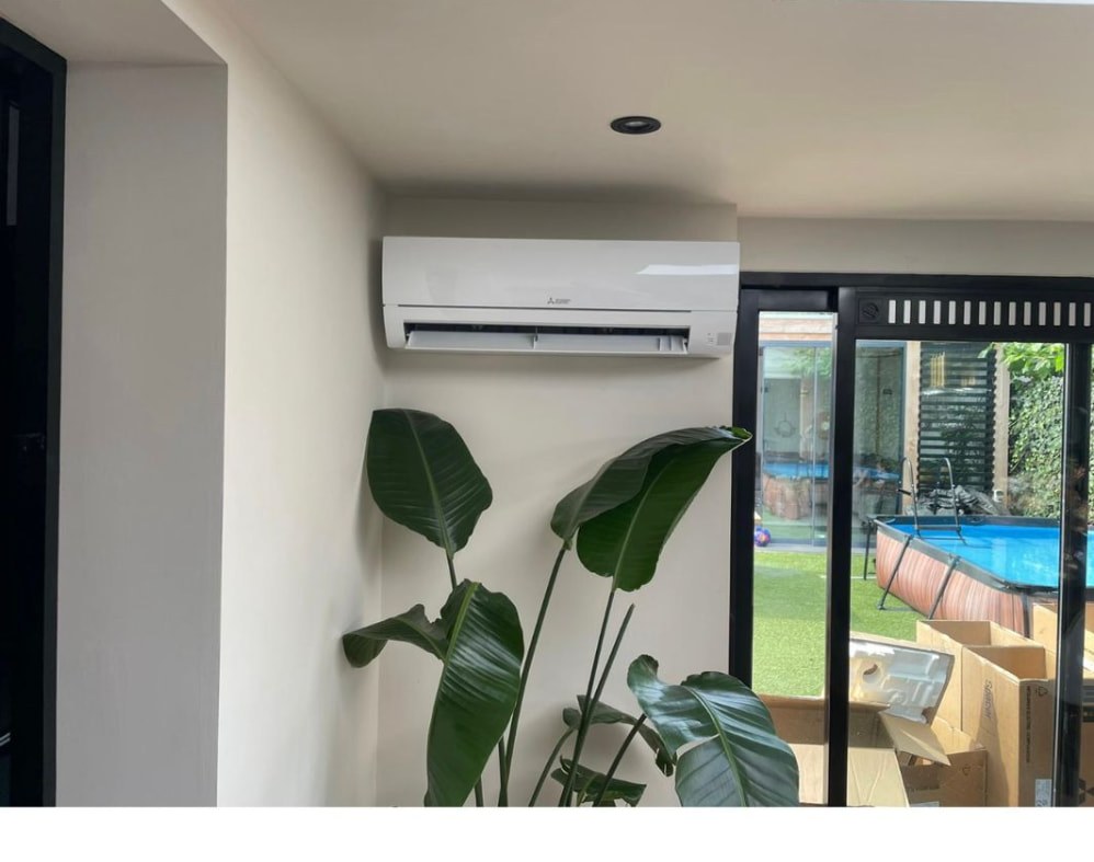 Mitsubishi wandunit naast de schuifpui van een tuinkamer